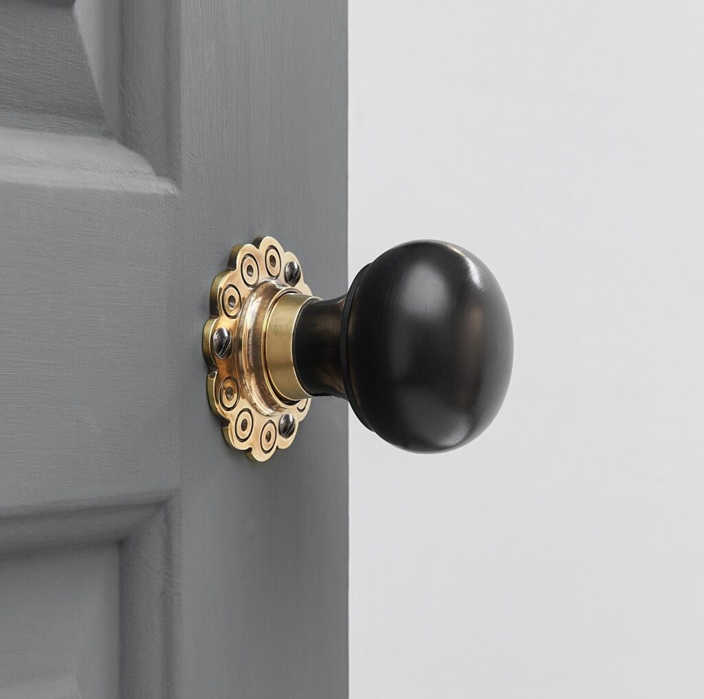 Ebony Bun Door Knobs in Aged Brass